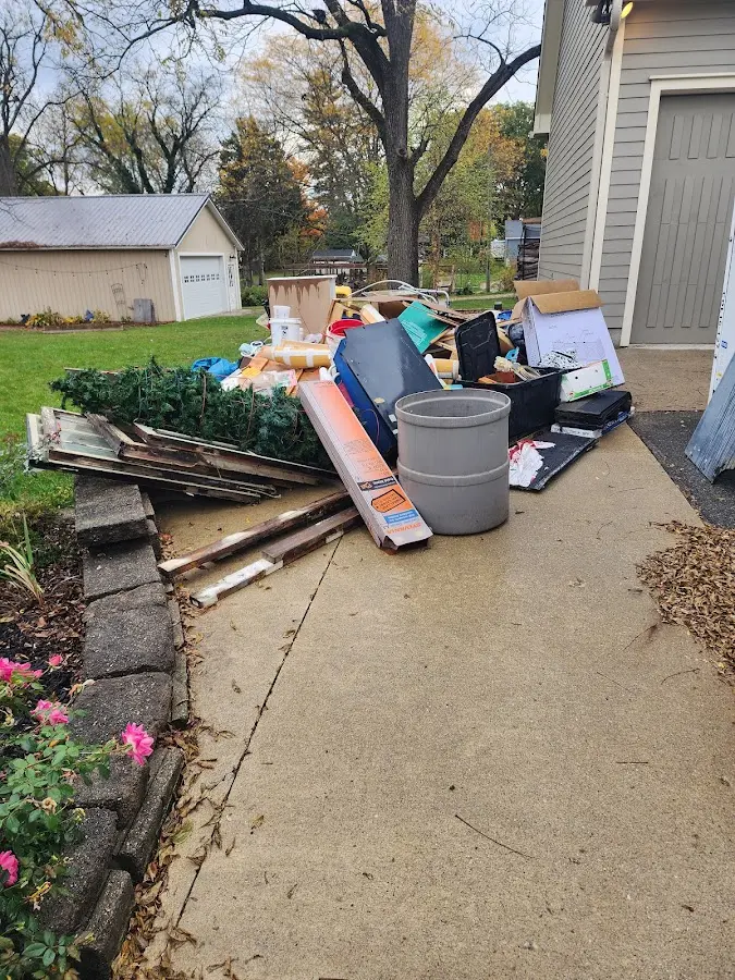 Dumpster being loaded with debris for Estate Cleanout Dumpster Rental in Ozark